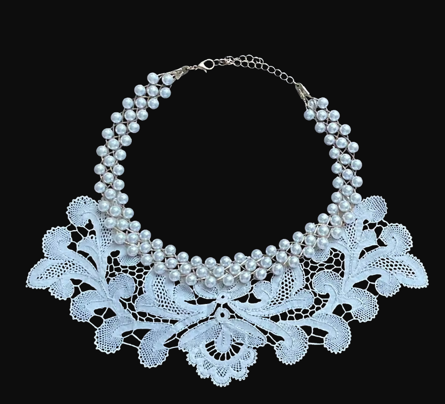 Ogrlica napravljena od ručno rađene lepoglavske čipke kao ovratnik povezan sa trakama sitnih bisera u svečanu ogrlicu.