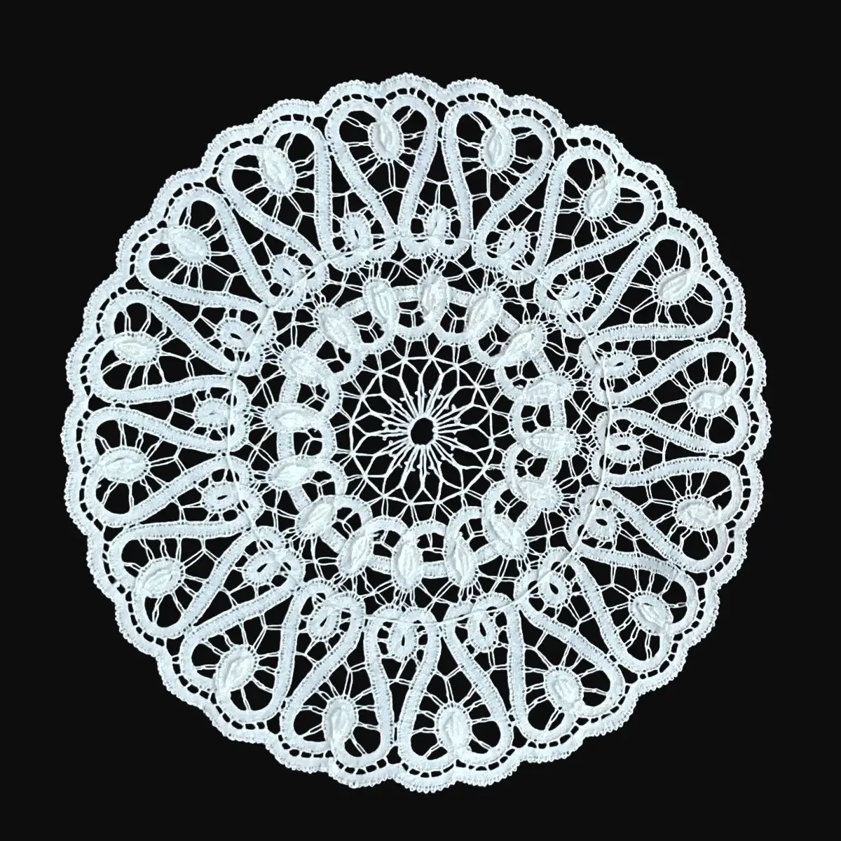 Ručno rađeni tabletić od čipke na batiće napravljen od tankog bijelog konca, u obliku kruga ispunjenog zavijutcima u obliku slova s i sa tankom stazicom koja uokviruje zavijutke.